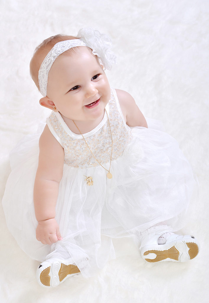 Bébé en robe blanche en séance photo à Laval Québec